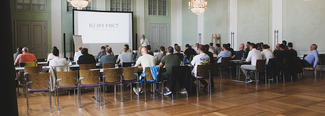Präsentation während der Tagung mit Teilnehmenden im Saal zu Themen wie Marketing und Kommunikation