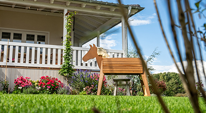 Holz-Spielpferd im Garten als Beispiel für einen kindgerechten Familiengarten