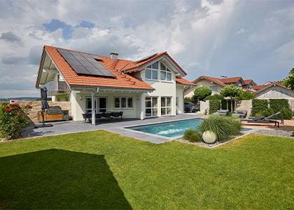 Modernes Wohnhaus mit gestaltetem Garten, Pool und Rasenfläche.